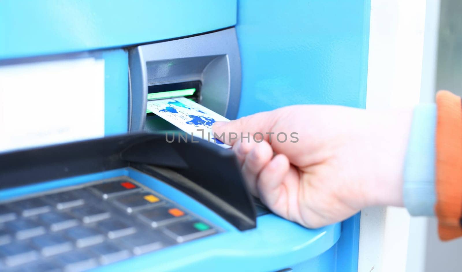 Male hand hold credit card aganist ATM by kuprevich