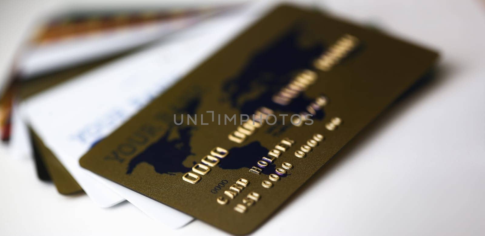 Many plastic card lie on table white and gold color background