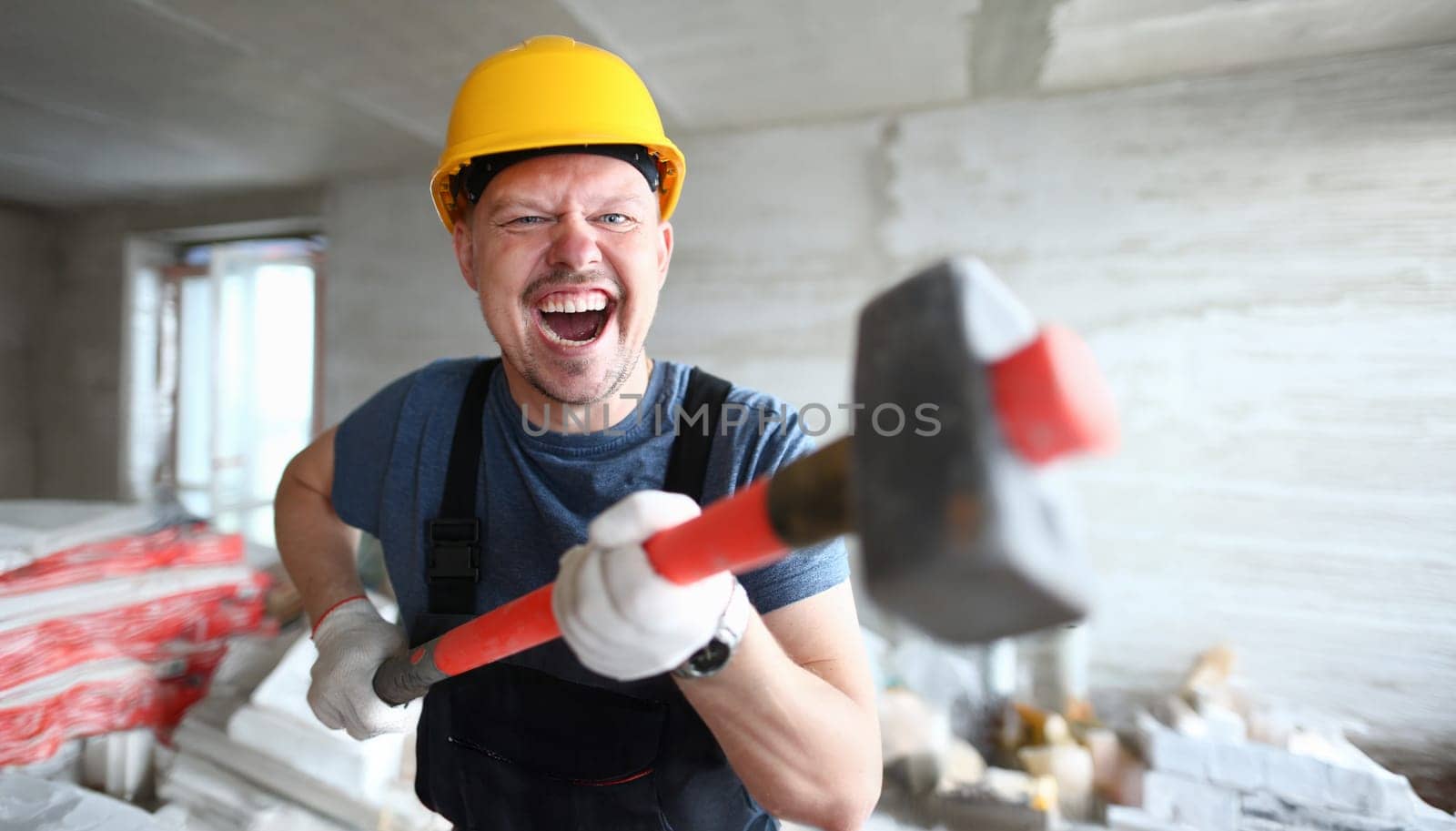 Angry builder holding sledgehammer and shouting at customer on floor apartment under repair. Quick dismantle concept noise walls.