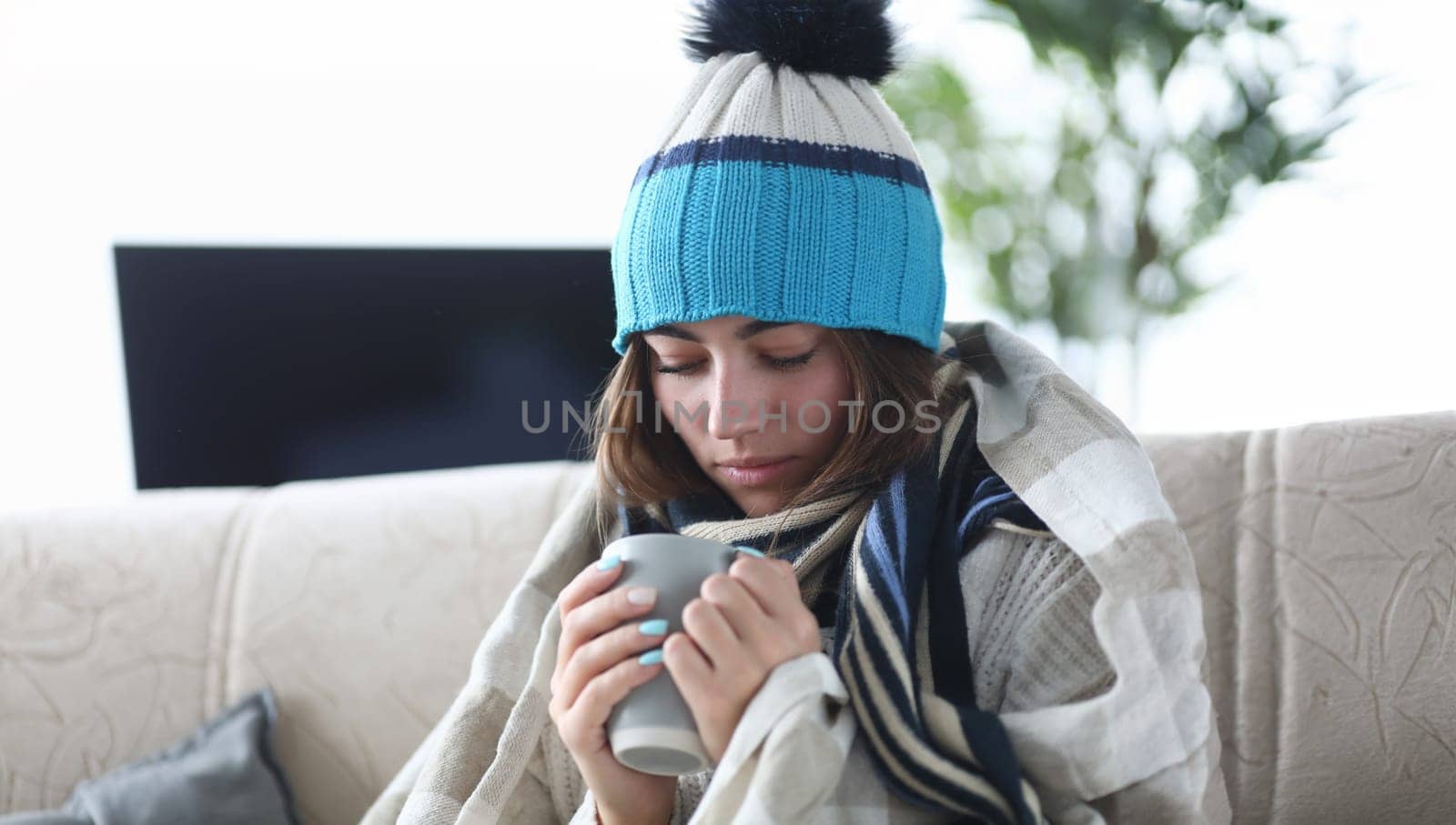 Portrait of smart lady sitting in living room and wearing warm clothes trying to cure sickness with traditional methods from severe illness. Hard virus concept