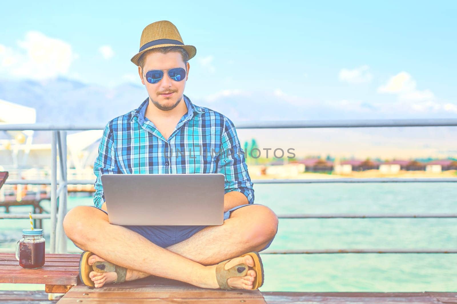 A man during the weekend, at sea, working on a laptop.