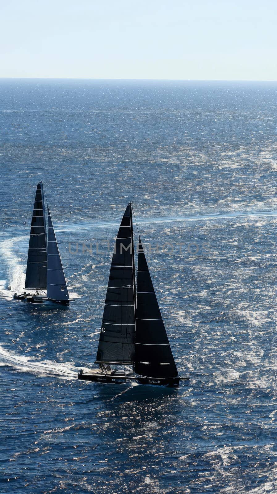 High-speed racing sailboats slice through the ocean waves, their sails billowing in the wind during a competitive regatta. by sfinks