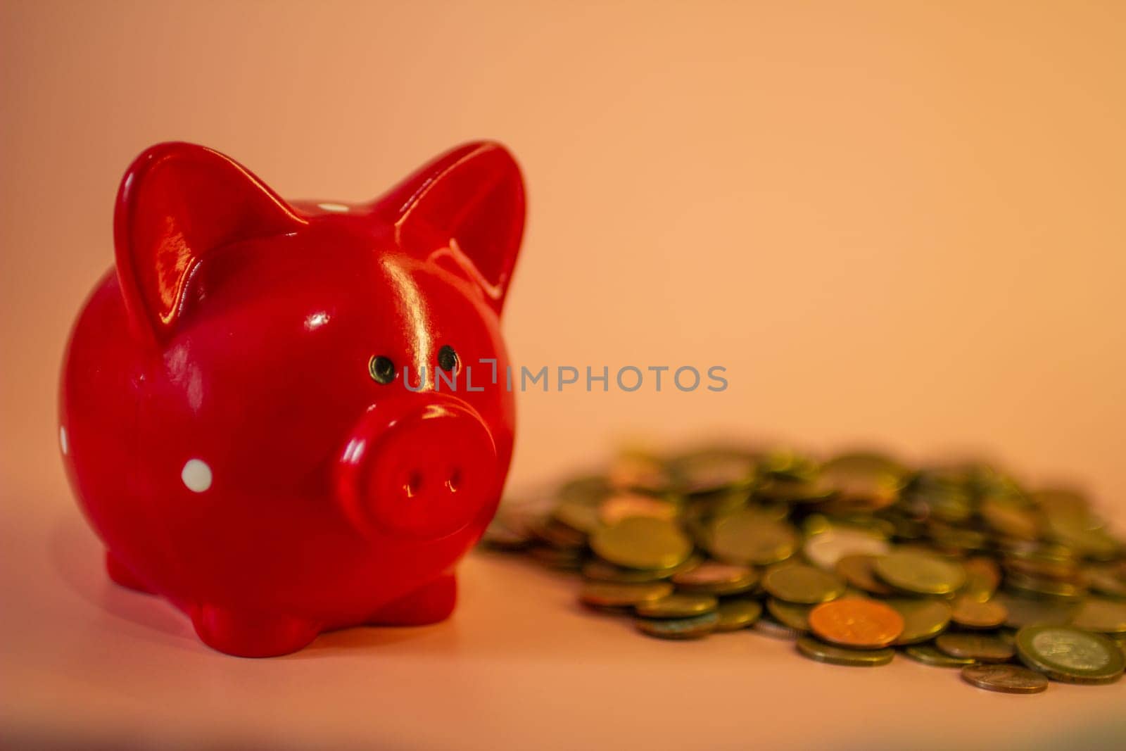 A red piggy bank full of coins. High quality photo
