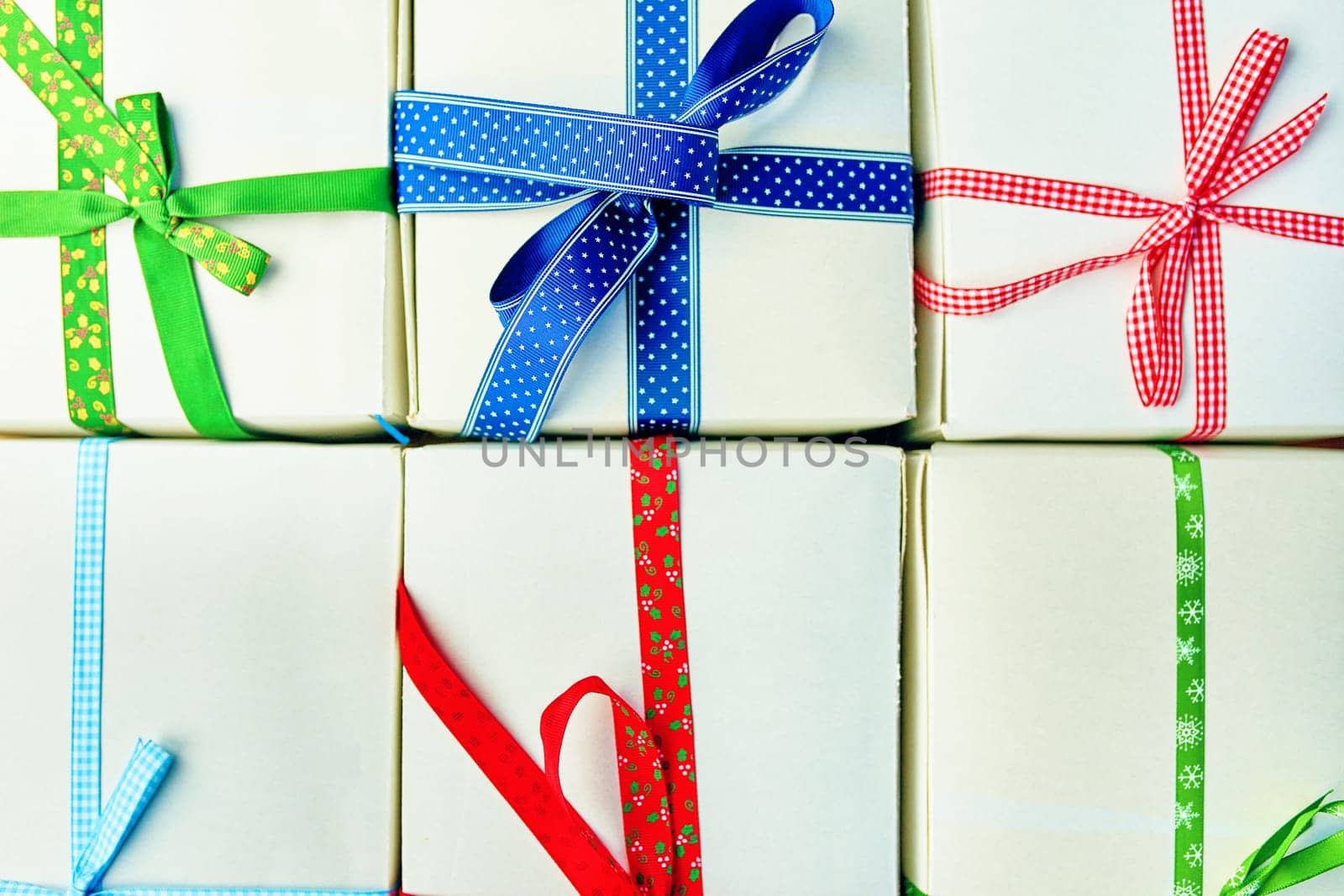 Stack of gift wrapped Christmas presents. Pile of boxes is stacked neatly on the table. View from above.