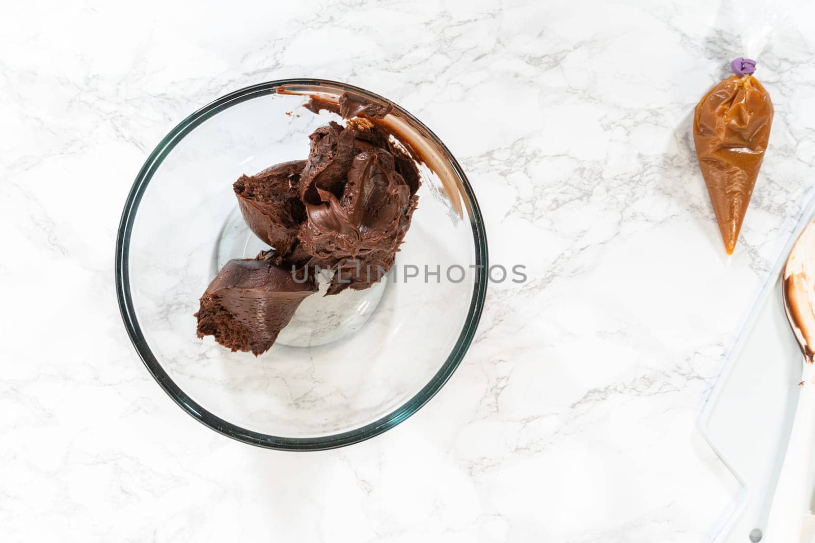 Flat lay. The frosting is whipped to perfection before being piped onto the delicious chocolate cupcakes.