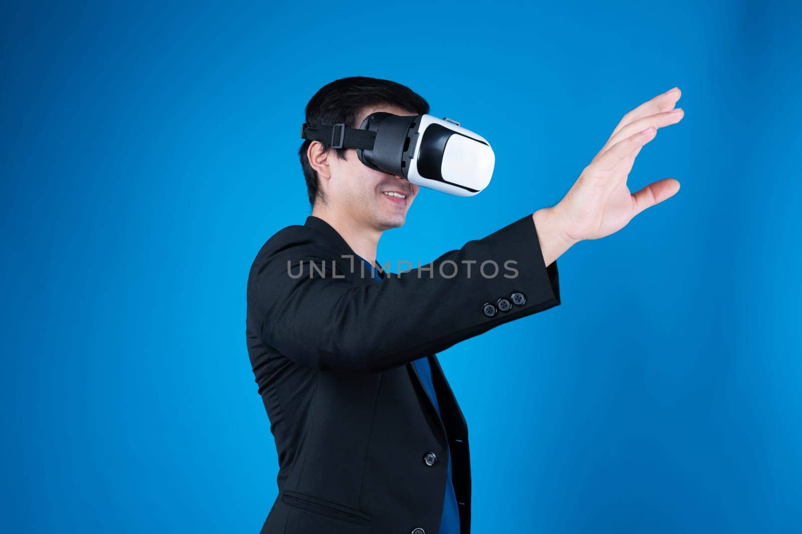 Profile businessman wearing VR headset looking to connect metaverse searching by touching slide with interesting data isolated blue background futuristic technology in virtual reality. Contrivance.