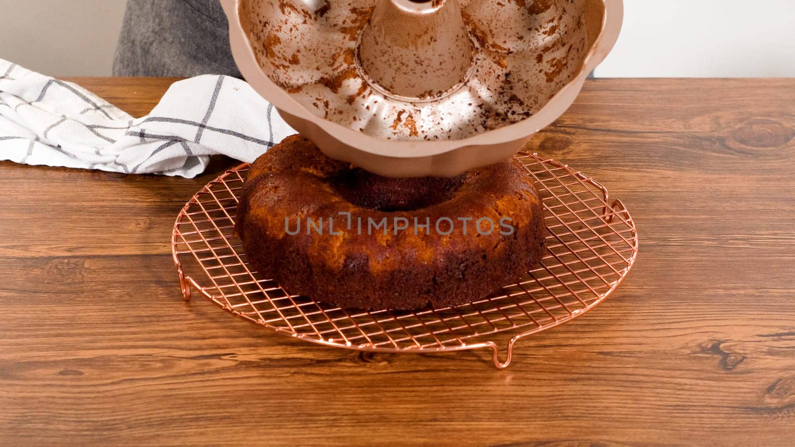 The gingerbread bundt cake gently eases out of its mold onto a wire rack, poised for a drizzle of sweet caramel frosting.