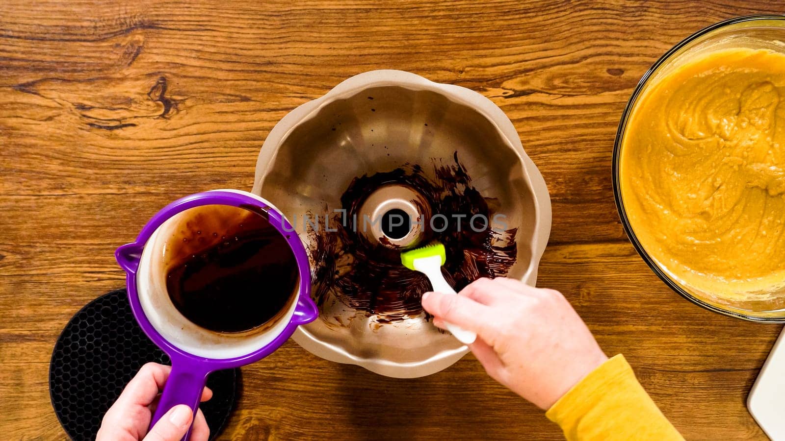 Flat lay. Carefully greasing a bundt cake pan in preparation for baking a delicious gingerbread bundt cake with caramel frosting.