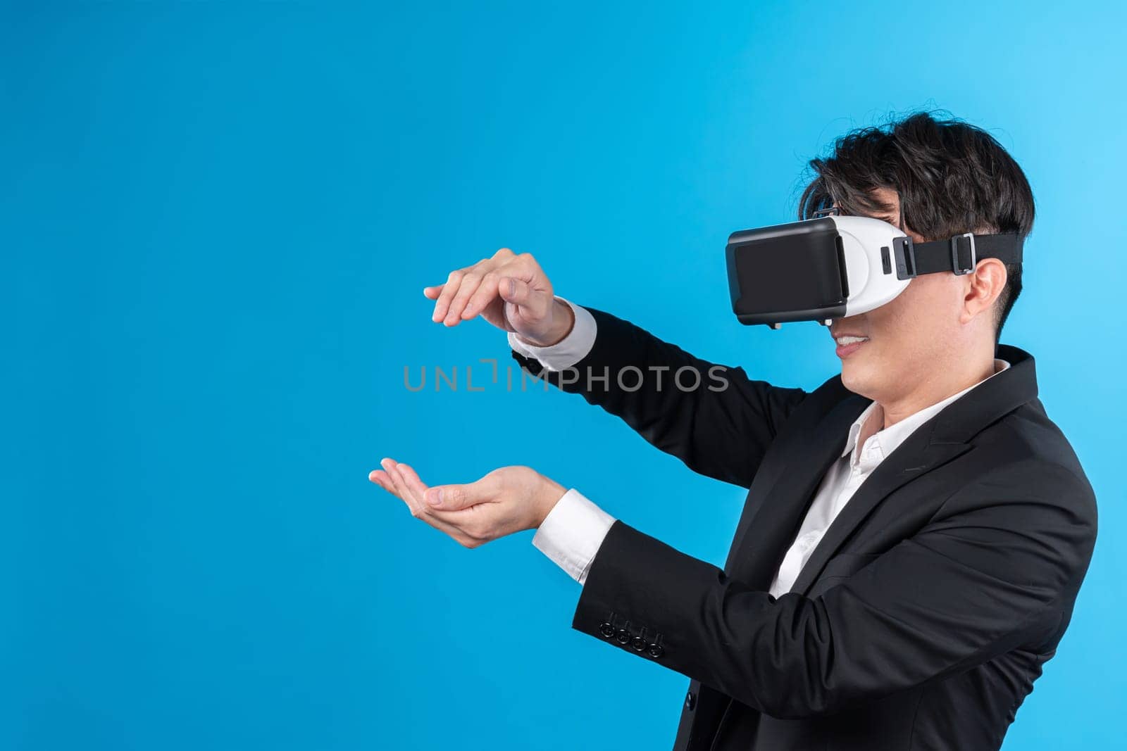 Asian businessman looking thorough VR try to zoom in or out with connecting business world report in futuristic metaverse analyzing innovation technology virtual reality blue copyspace. Contrivance.
