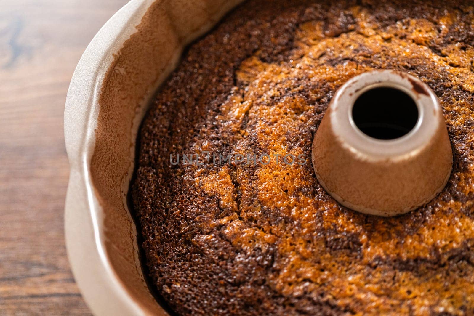 The gingerbread bundt cake cools gracefully on a wire rack, awaiting its sweet caramel frosting.