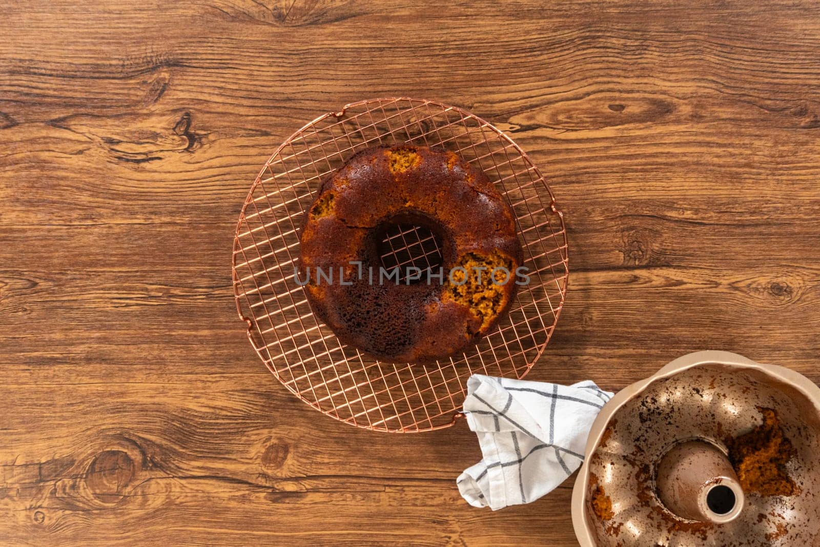 Flat lay. The gingerbread bundt cake cools gracefully on a wire rack, awaiting its sweet caramel frosting.