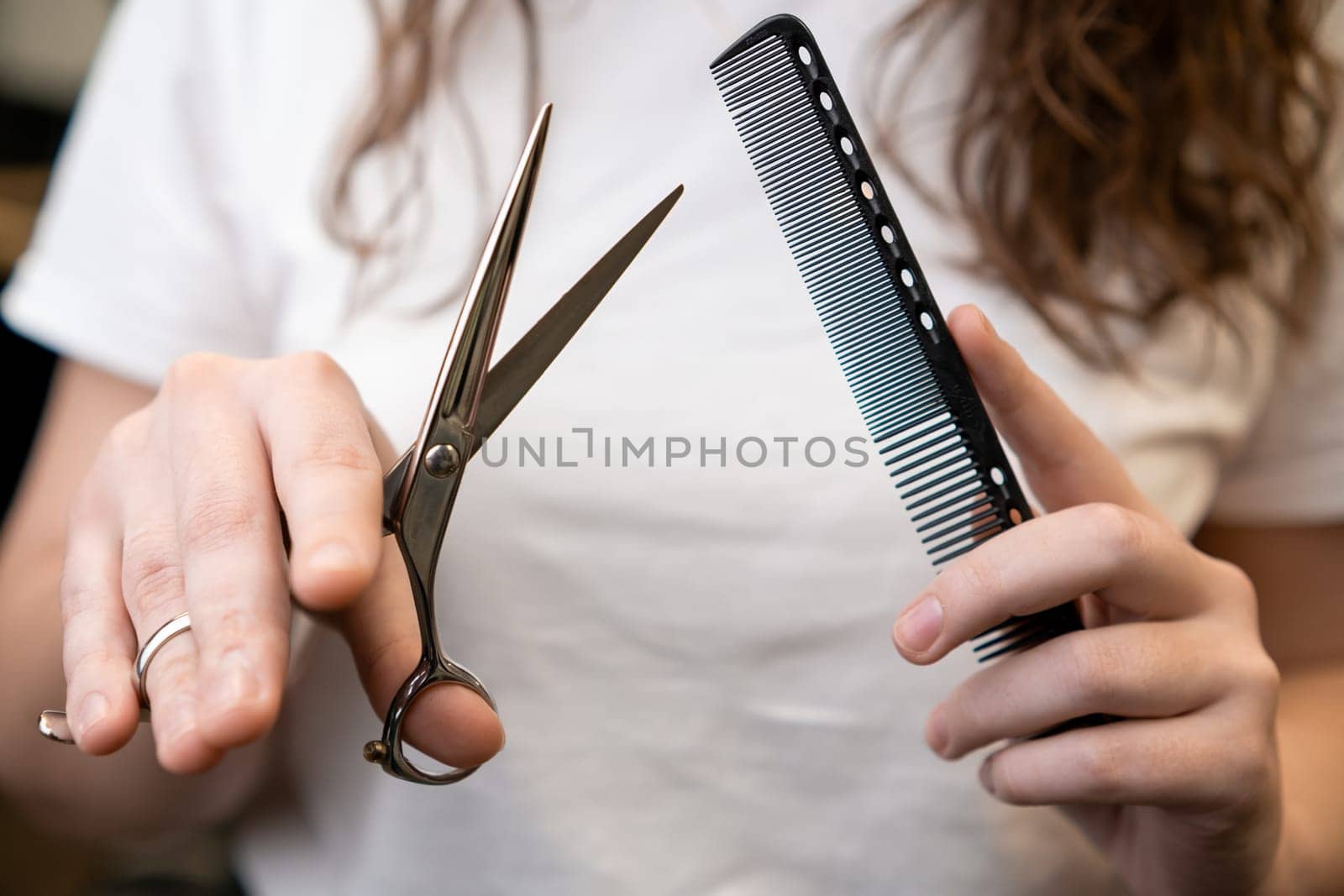 Scissors and comb in the hands of female barber