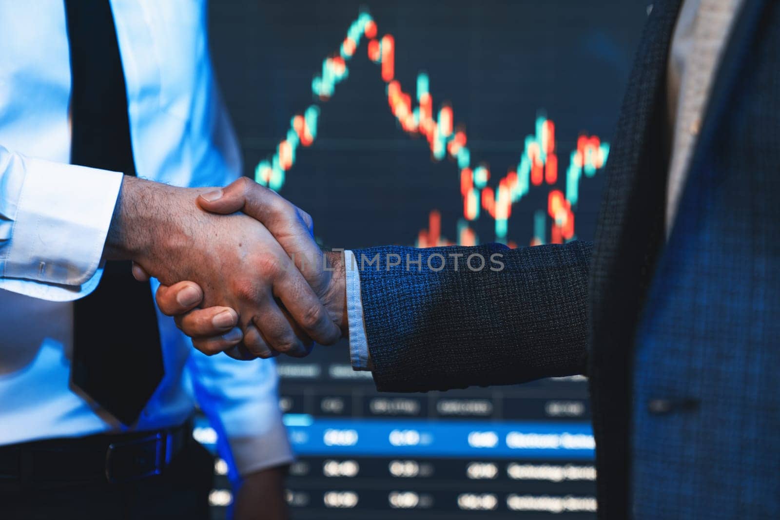 Investor stock trading of business partners shaking hands against screen for cooperating of investing agreement of highest valued technology product trending on the dynamic market stock. Sellable.