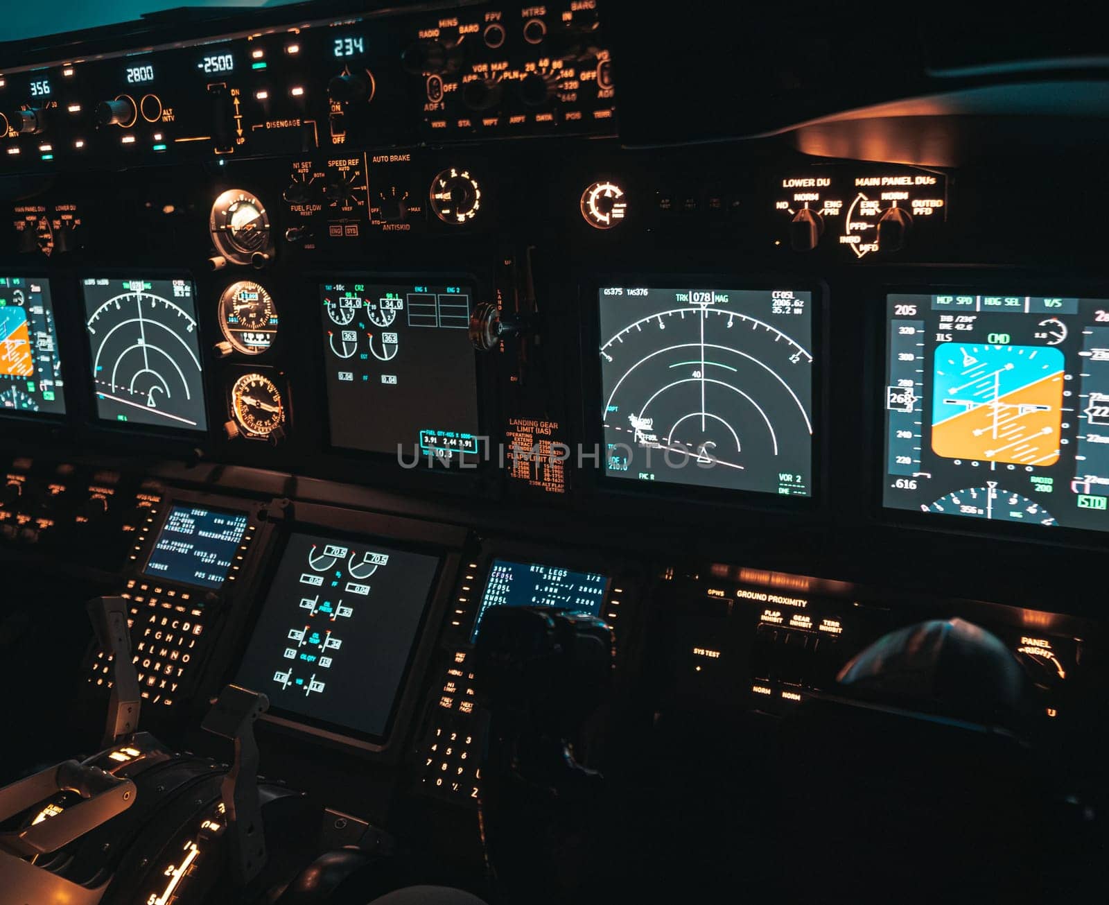 Cockpit view of an airplane during a night-time flight with illuminated instrument panels by Busker