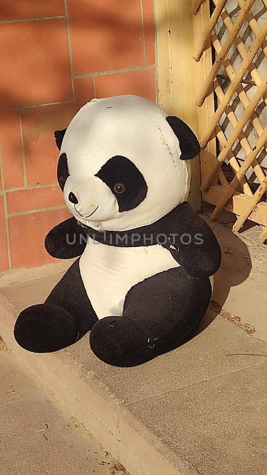 large soft children's toy panda bear thrown out on the street. High quality photo