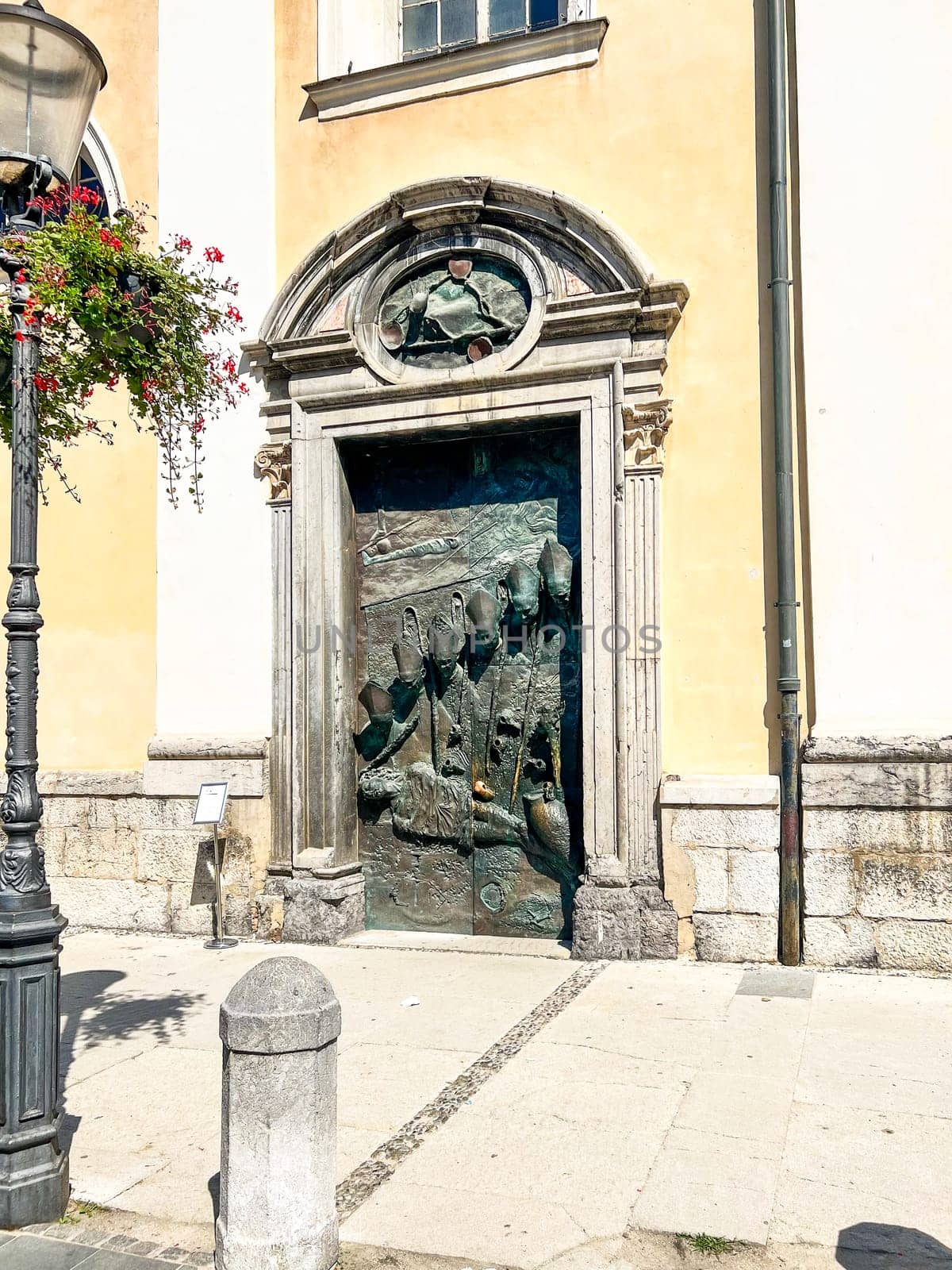 Ljubljana, Slovenia, August 15, 2023: Bronze door with six bishops of Saint Nicholas Cathedral at the old town of City of Ljubljana on a summer day