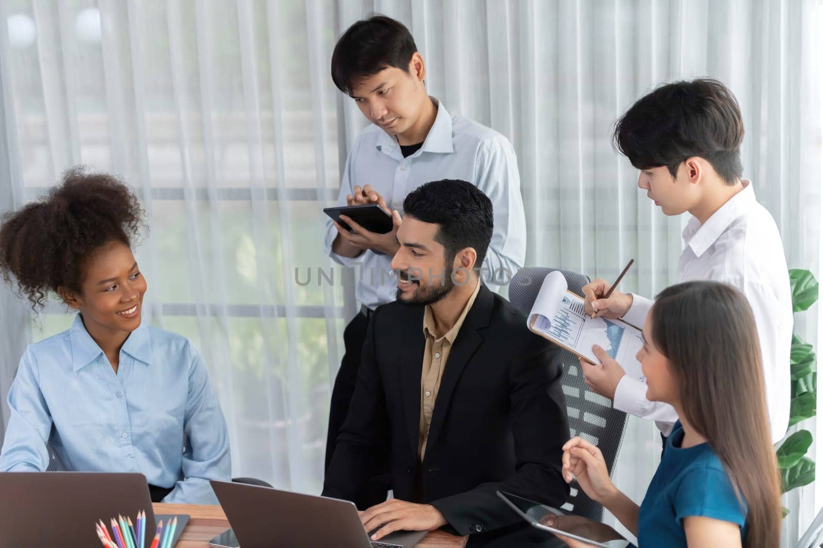 Happy diverse business people work together, discussing in corporate office. Professional and diversity teamwork discuss business plan on desk with laptop. Modern multicultural office worker. Concord