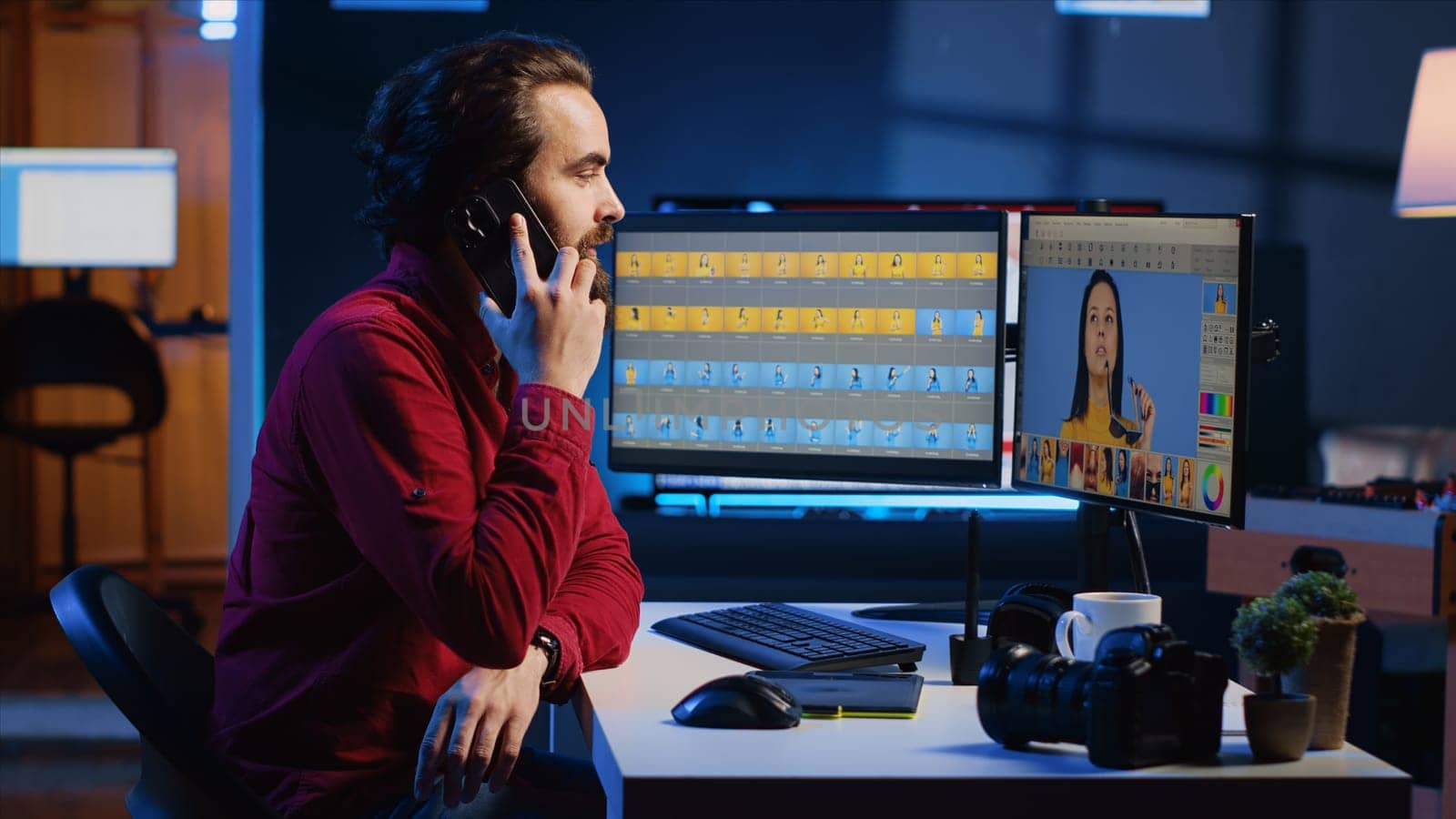 Photographer receiving phone call from client while editing his photos using advanced software. Photo editor talking on smartphone with customer while making photographs adjustments