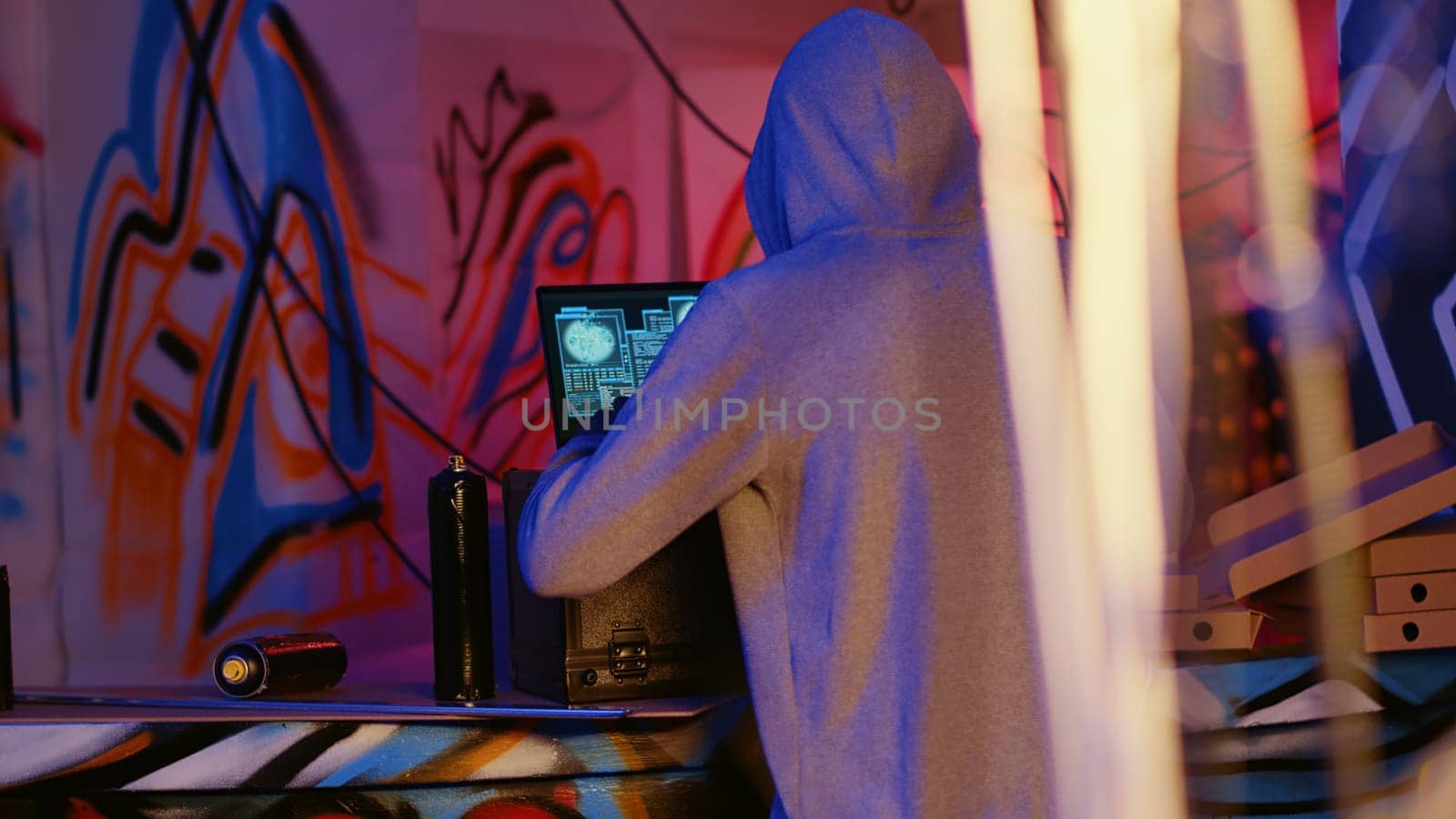 Close up shot of hacker in underground bunker using network vulnerabilities to exploit servers, trying to break computer systems at night. African American cybercriminal breaching networks