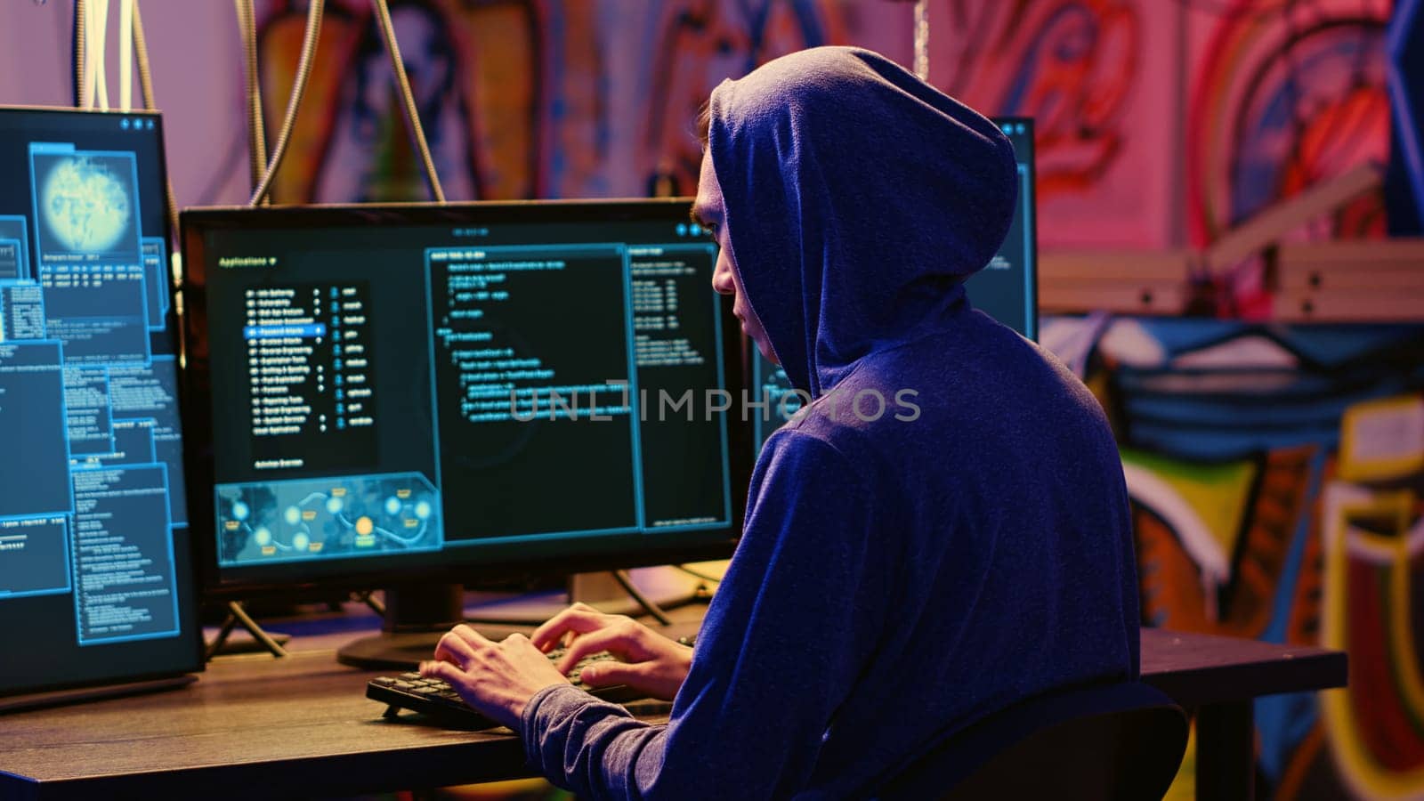 Hacker in graffiti painted hideaway base writing lines of code on computer, developing malware that get past security systems. Rogue programmer uses PC in bunker, running hacking script