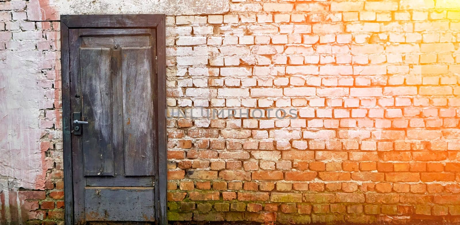 Rustic brick wall featuring a weathered blue wooden door with whitewash remnants by Hil