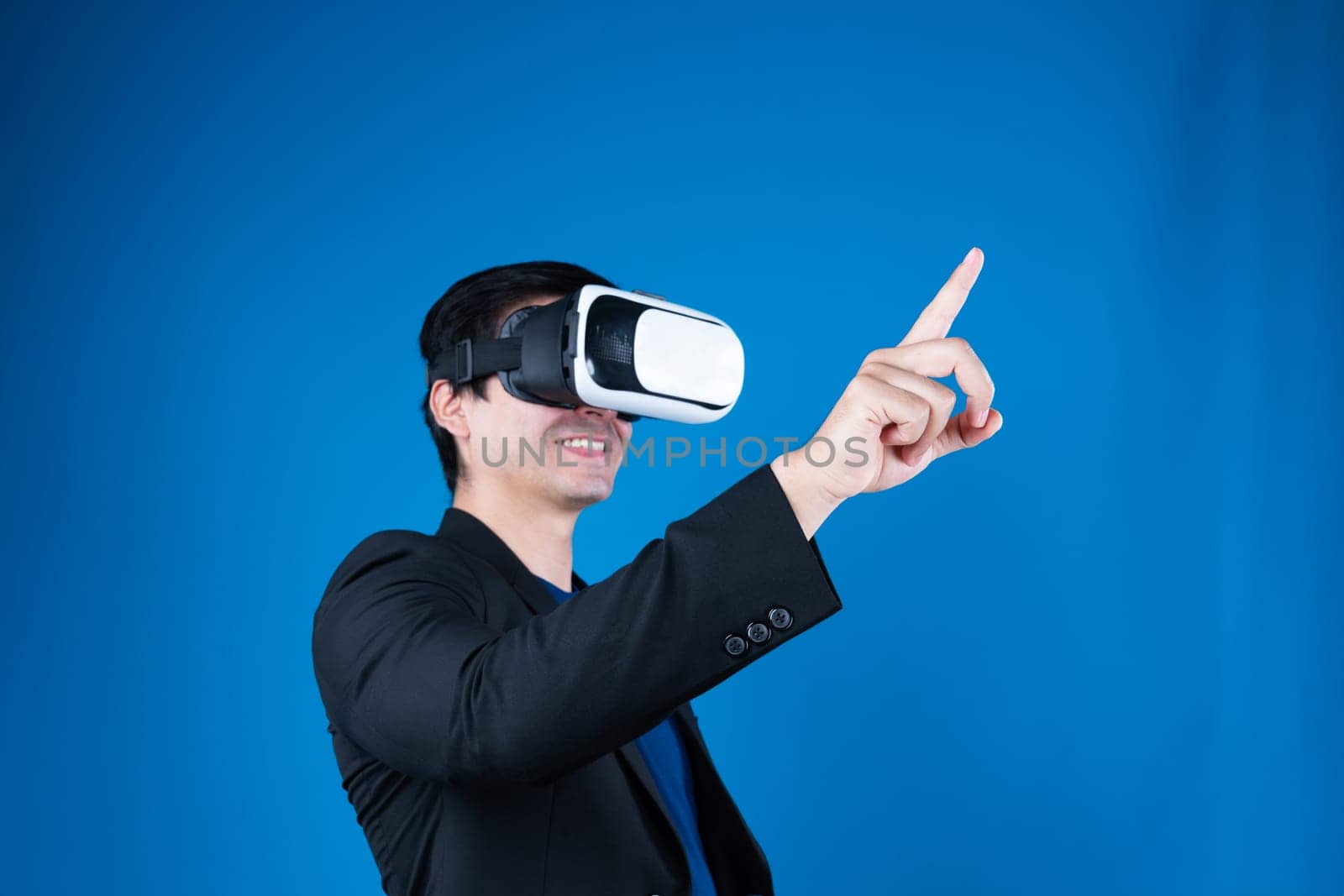 Profile businessman wearing VR headset looking to connect metaverse pointing to choose interesting data isolated blue background futuristic analytics communication tech virtual reality. Contrivance.