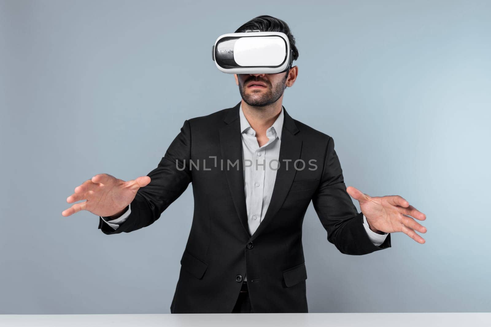 Skilled businessman looking at financial chart while wearing VR goggle. Professional project manager checking data analysis while connecting metaverse or virtual reality world. Innovation. Deviation.