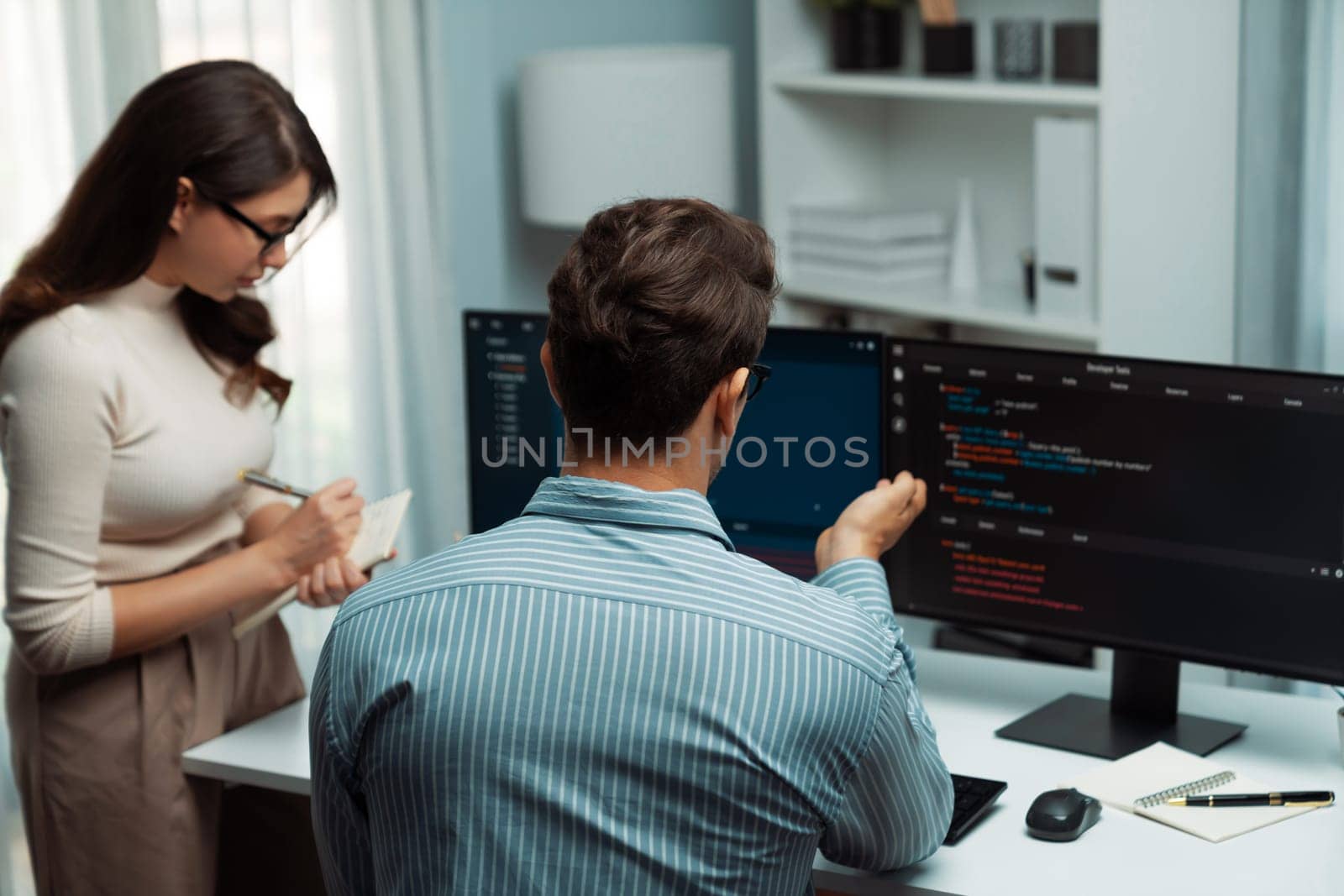 Team skilled developers program coding discussing creative website planning software project on two screen monitor's full stack data analyzing design at office with back side view concept. Postulate.