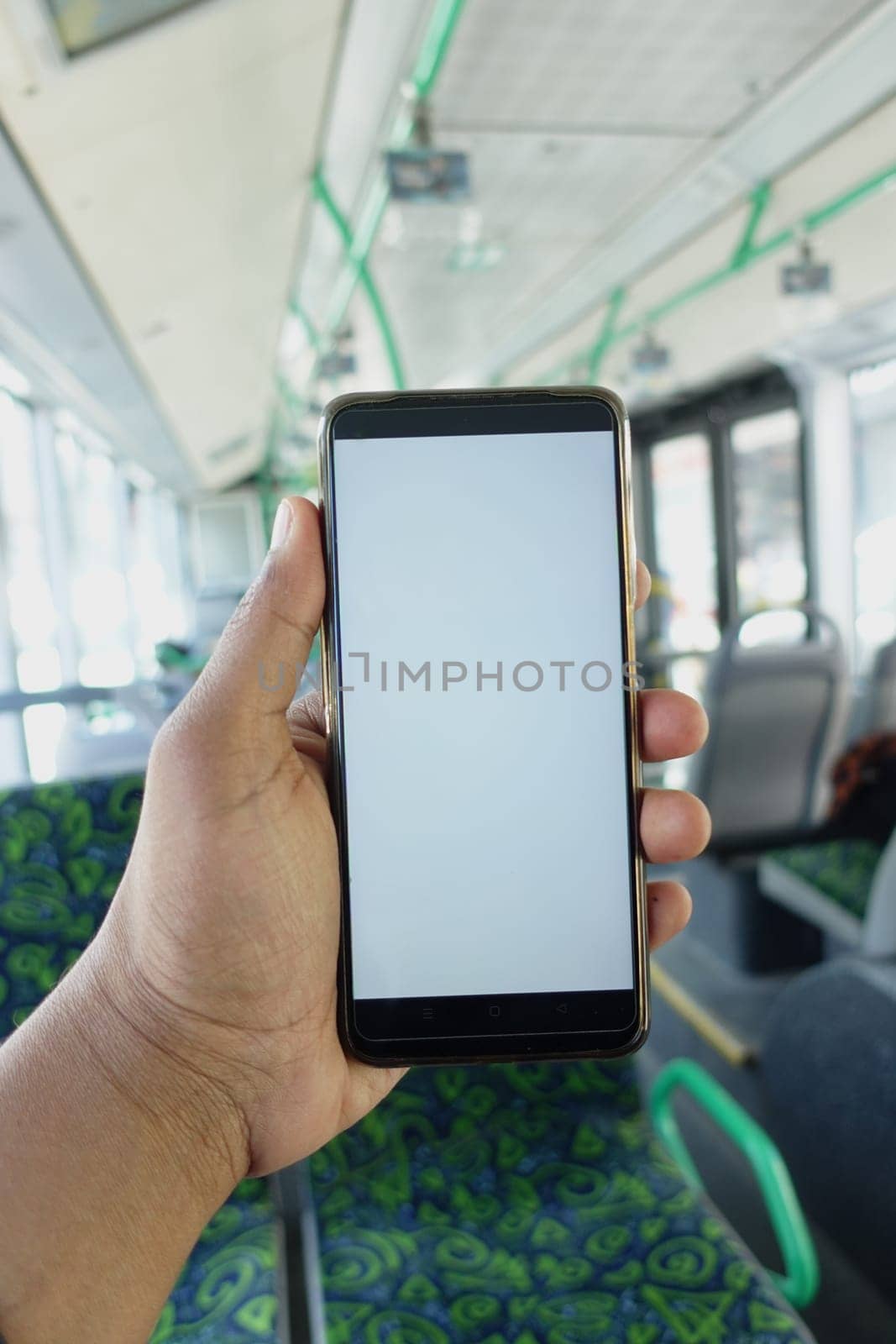 passenger sitting in a bus using his phone