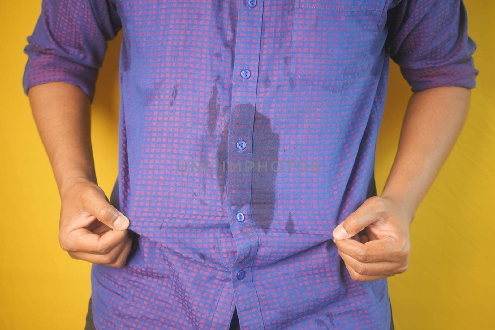 men hands with spilled water over his shirt.