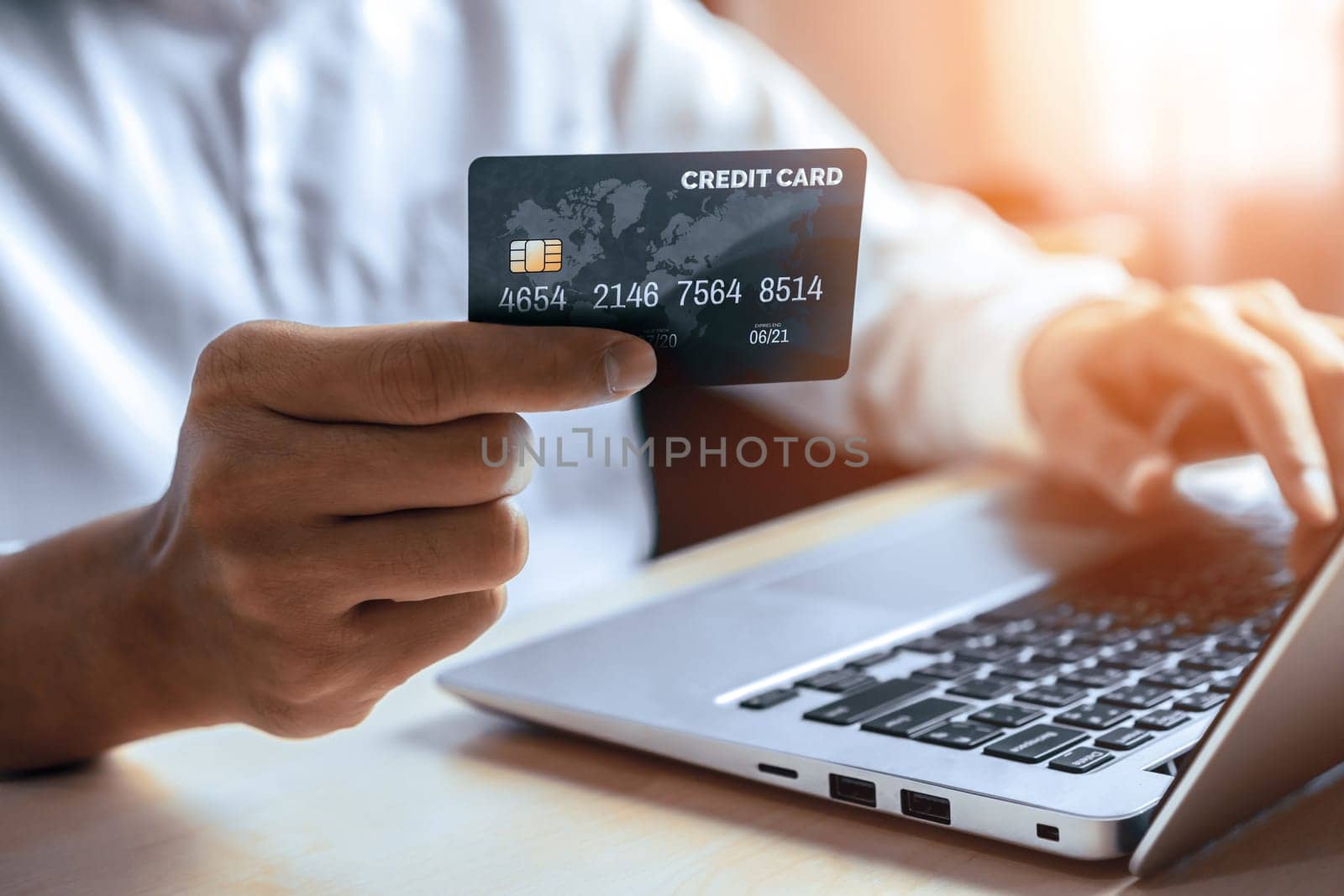 Young man use credit card for shopping payment online on laptop computer application or website. E-commerce and online shopping concept. uds