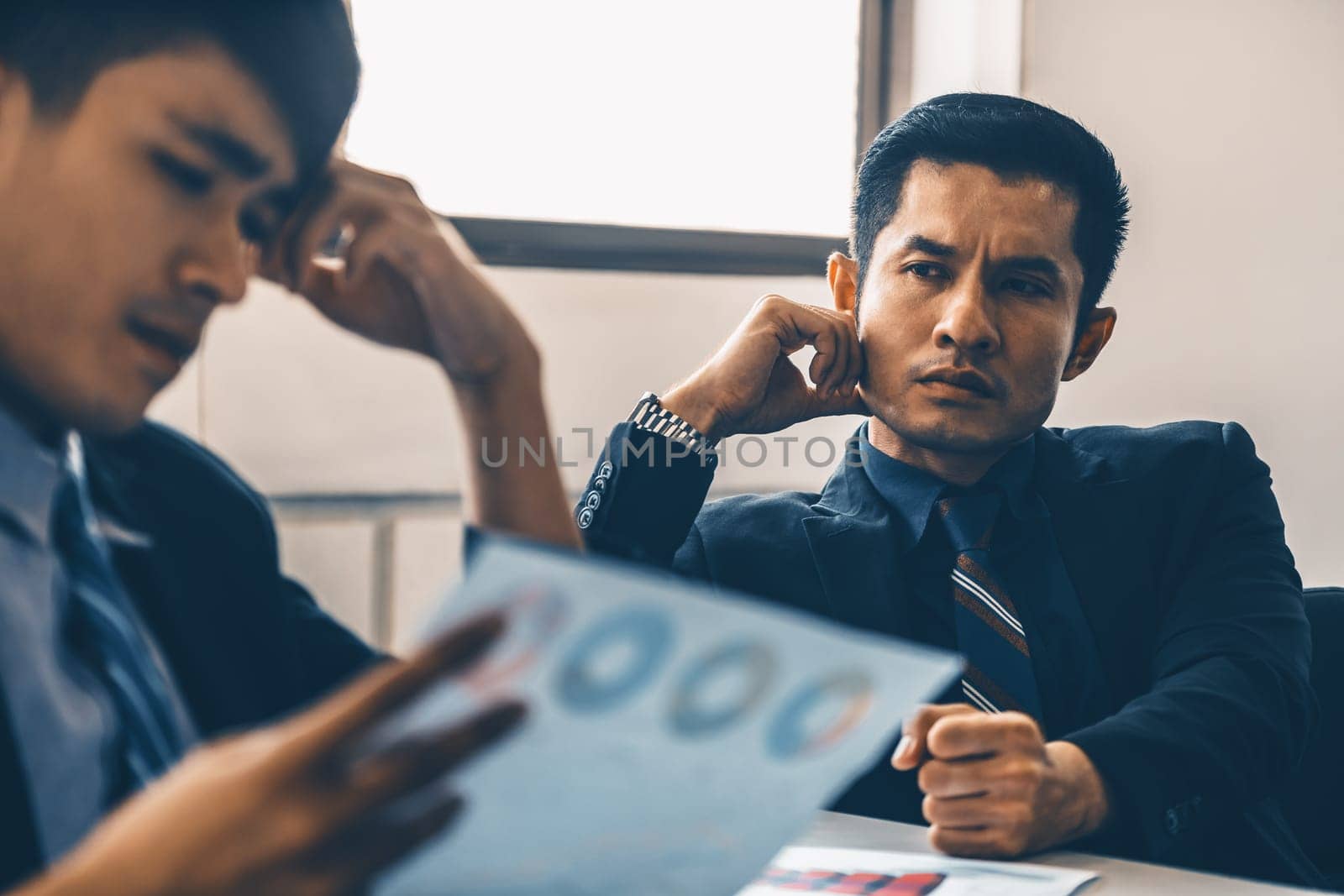 Unhappy business manager and young businessman partner in meeting room at the office. They are under stress because of bad financial document report. Company crisis concept. uds