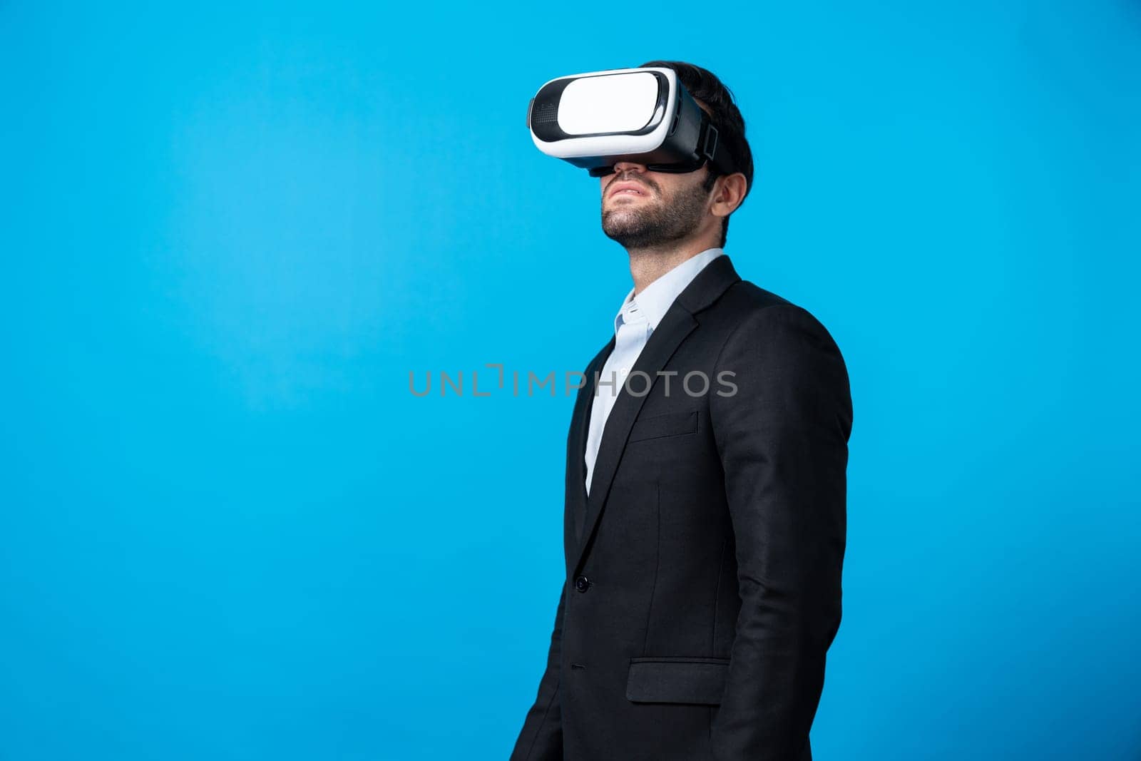 Skilled project manager with VR glasses standing and looking around. Caucasian businessman connecting with metaverse and virtual reality world while wearing suit. Innovation technology. Deviation.