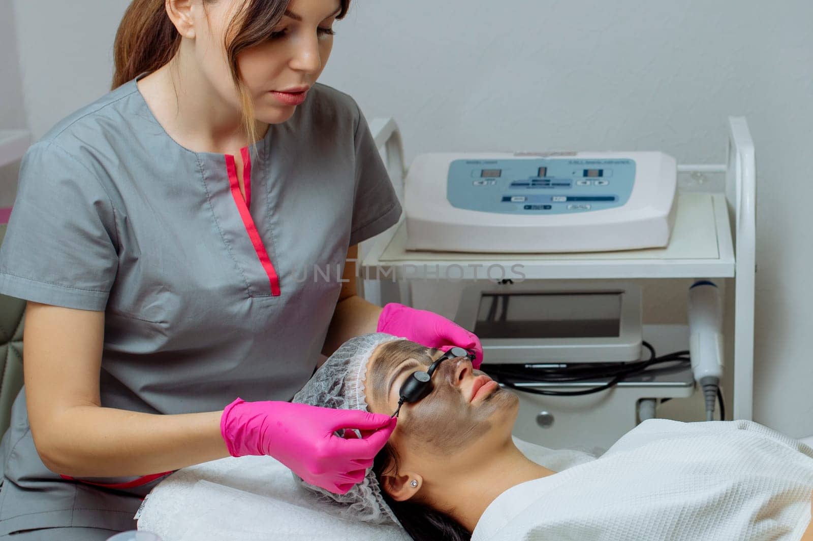 Close-up of carbon peeling procedure for middle-aged woman face. Laser pulses clean skin. Process of photothermolysis, warming, laser carbon peeling. Facial skin rejuvenation, cosmetology treatment