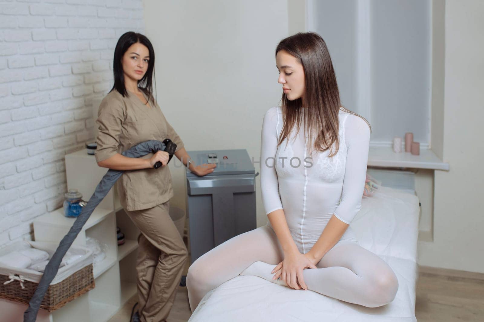 Woman in special white suit getting anti cellulite massage in a spa salon. LPG, and body contouring treatment in clinic.Reset body weight with LPG massage.