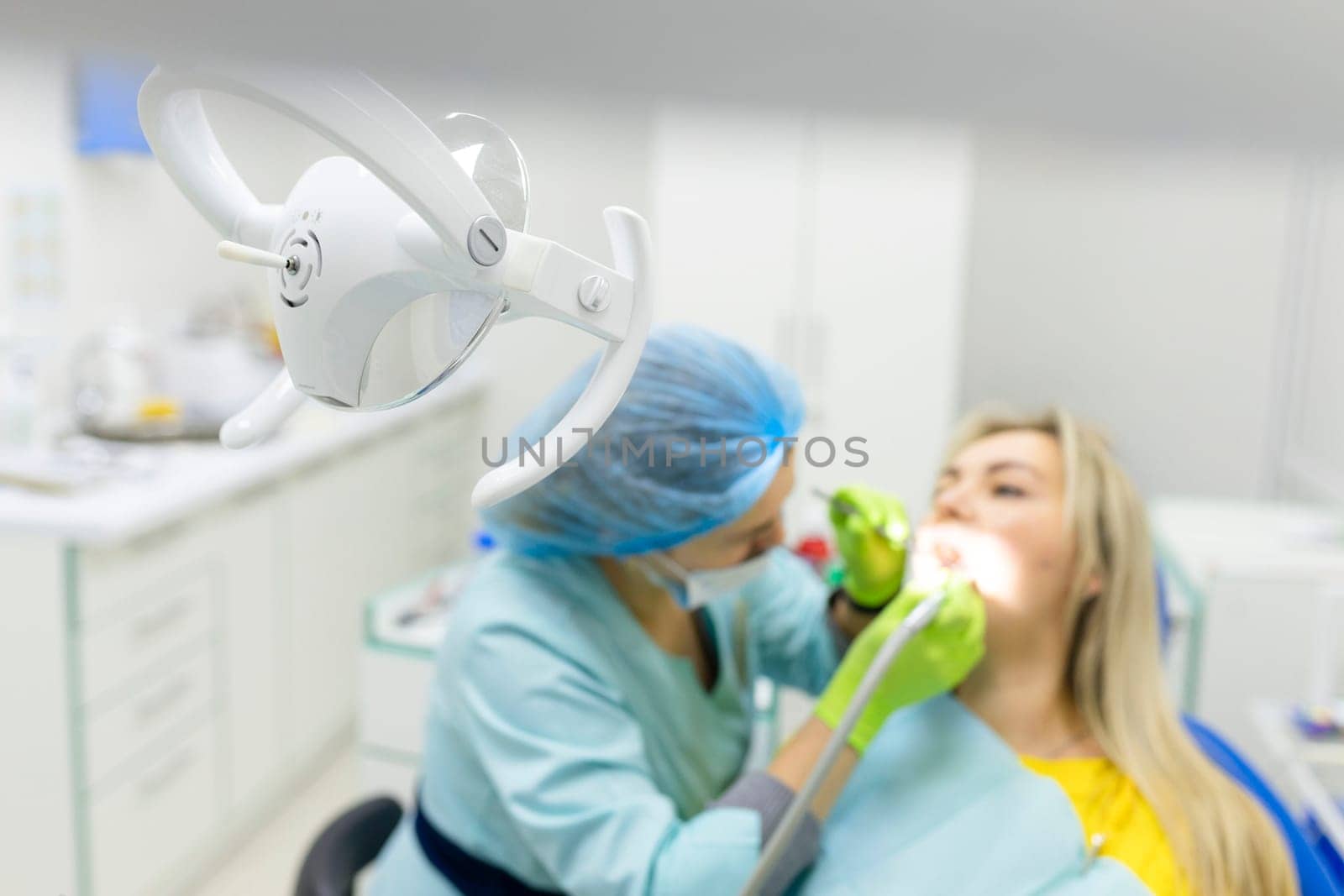 dentist drills the lower tooth to the patient sitting in a chair. High quality photo