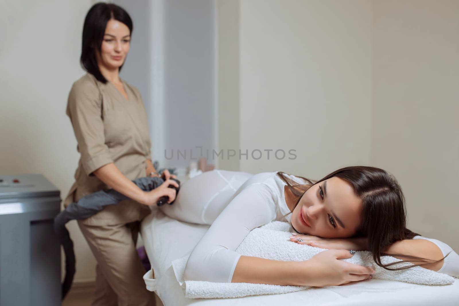Woman in special white suit getting anti cellulite massage in a spa salon. LPG, and body contouring treatment in clinic.Reset body weight with LPG massage.