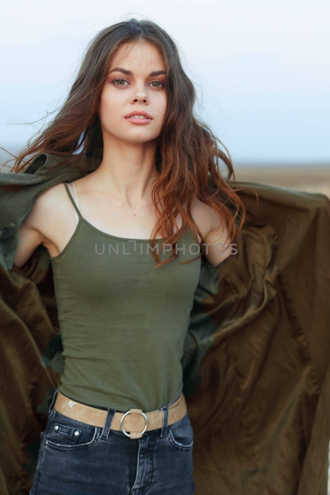 empowered woman with outstretched arms standing in vast desert landscape