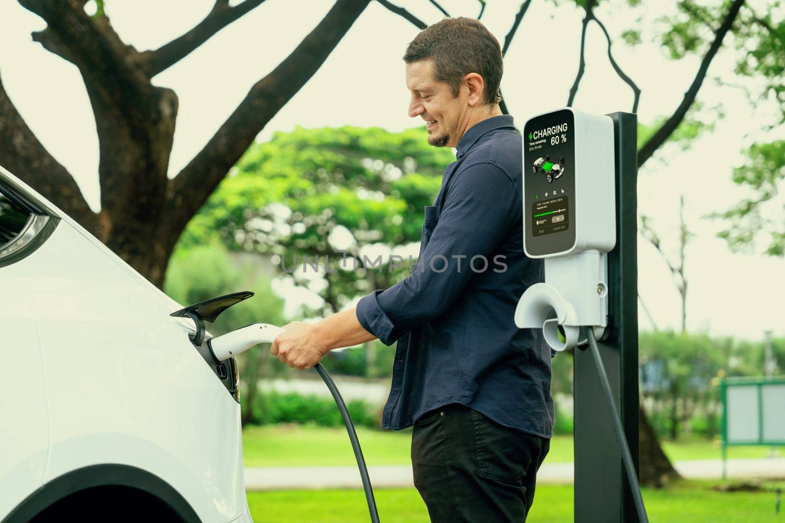 Man recharge EV electric vehicle battery from EV charging station. Exalt by biancoblue