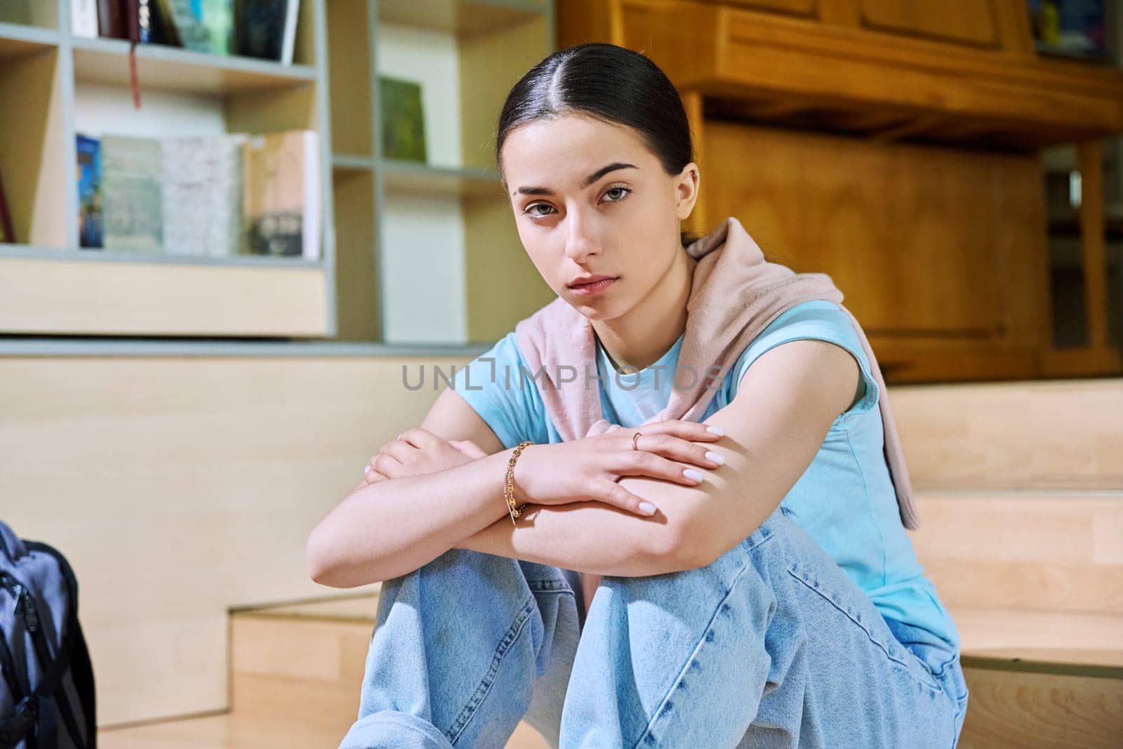 Serious teenage girl high school student sitting in class looking at camera. Education, teenagers 16-17 years old, adolescence concept