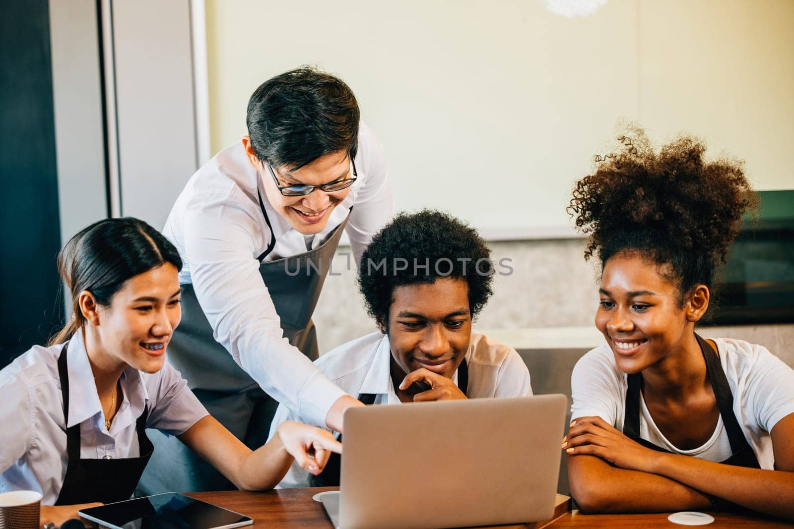 In the coffee shop business young entrepreneurs find joy fun pride. Planning managing with laptop brings satisfaction. Baristas owners collaborate for success teamwork.