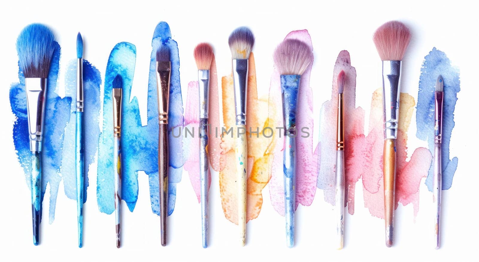 Watercolor brushes splattered with blue, pink, and yellow paint on white background for artistic creations