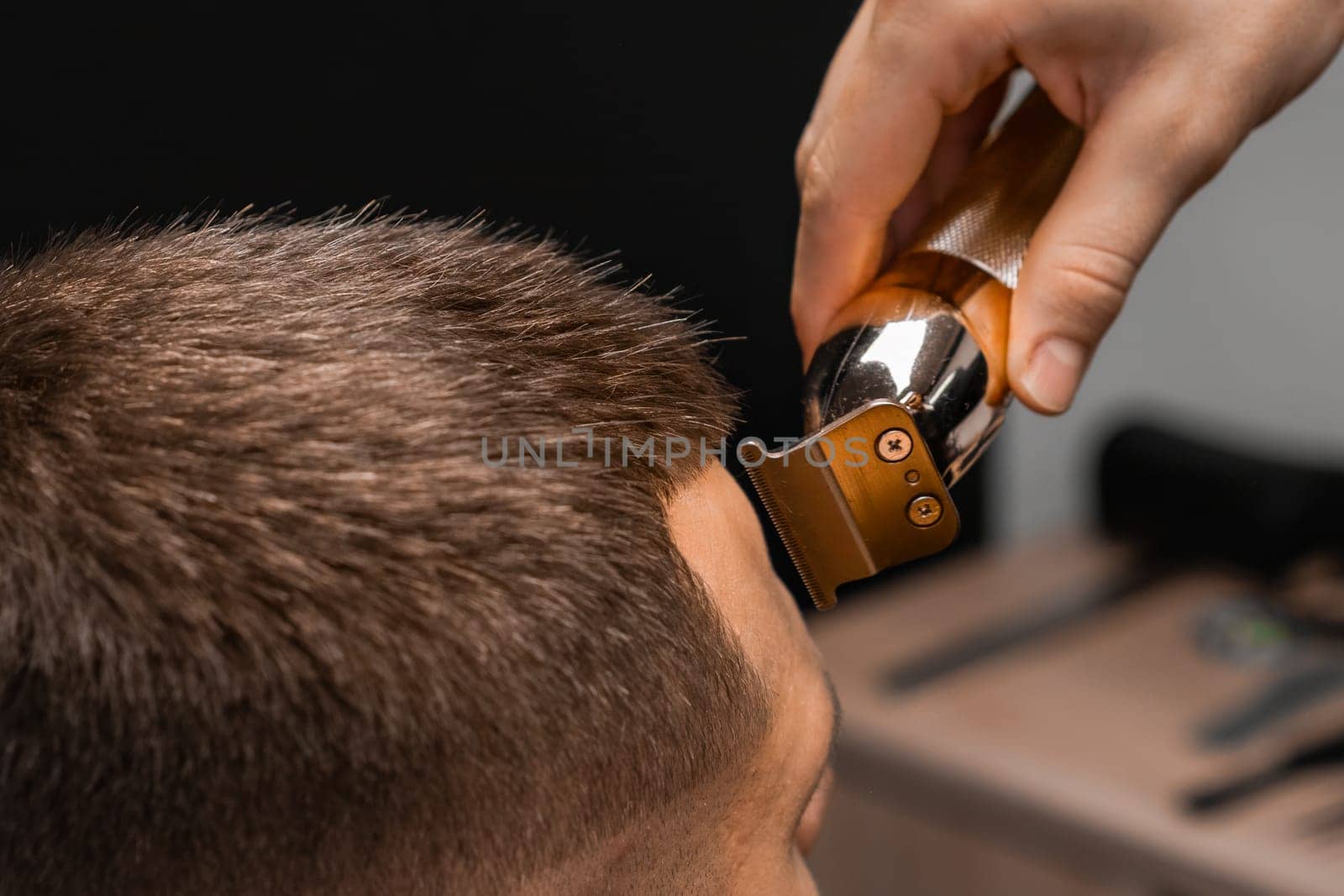 Close up hairdresser shapes mans hair on the forehead.