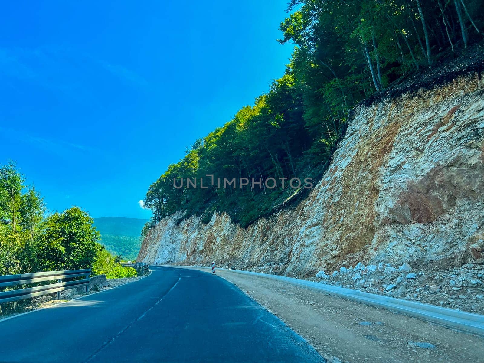 Rocky slope of the road, roadside erosion, road in the rock, Bosnia, photo