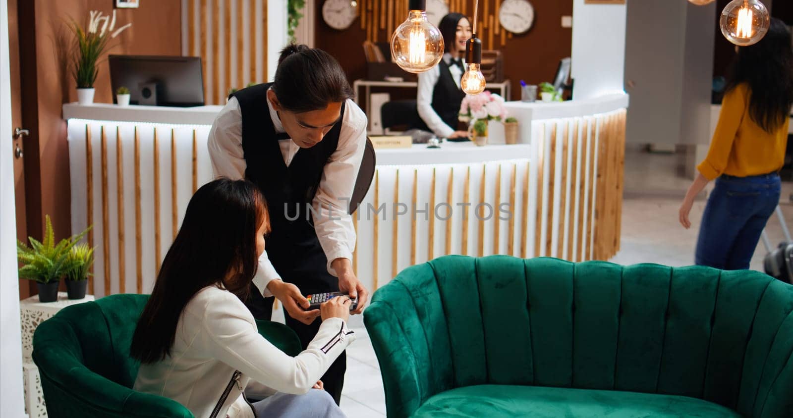 Pleased client giving cash to waiter after paying for coffee, using pos terminal for credit card payment and enjoying good customer services at five star hotel. Woman offering money to staff.