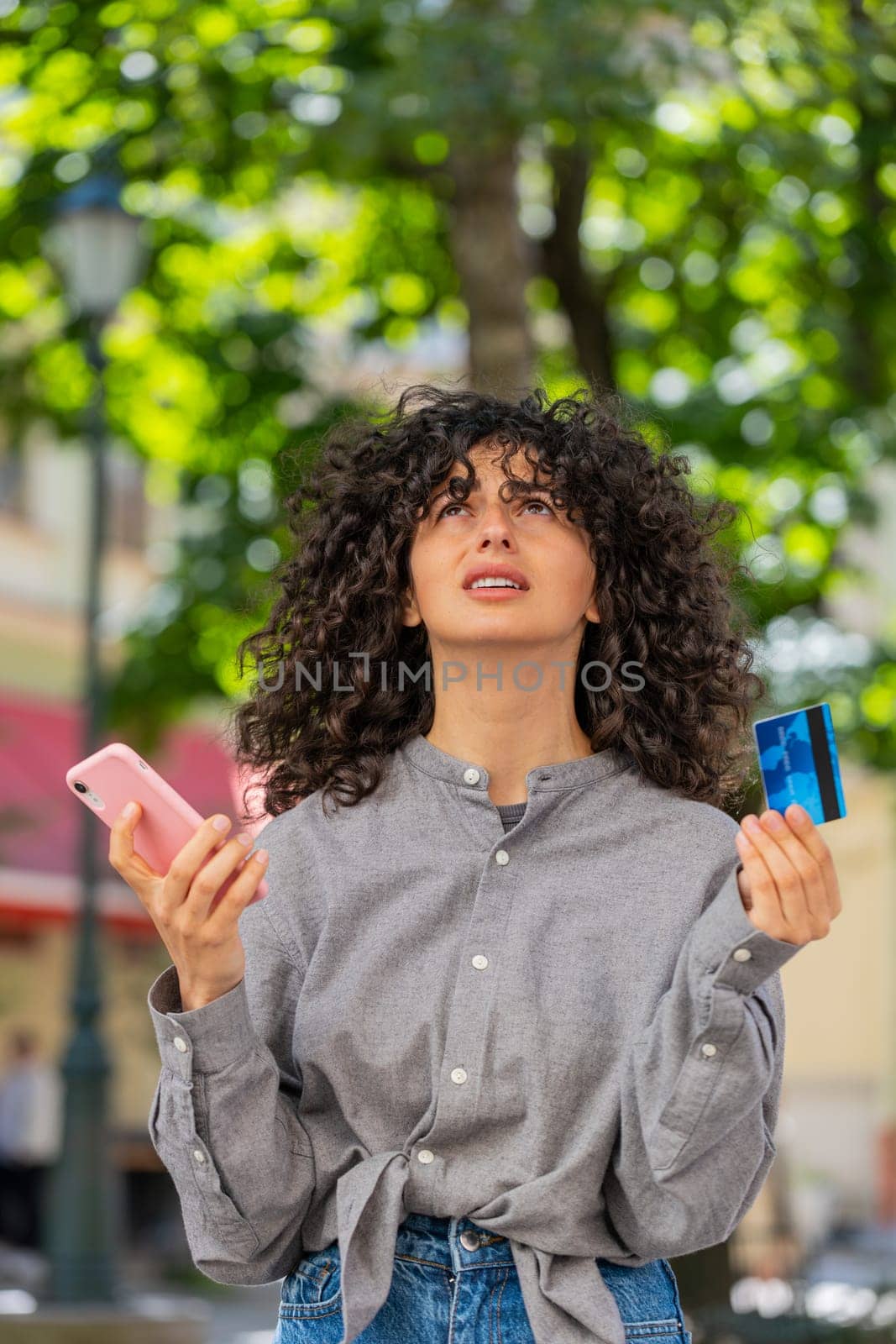 Angry woman trying to pay online shopping with smartphone blocked credit card. Annoyed girl tourist on street buying bank refuse problem unsuccessful payment lack of money balance bankrupt. Vertical