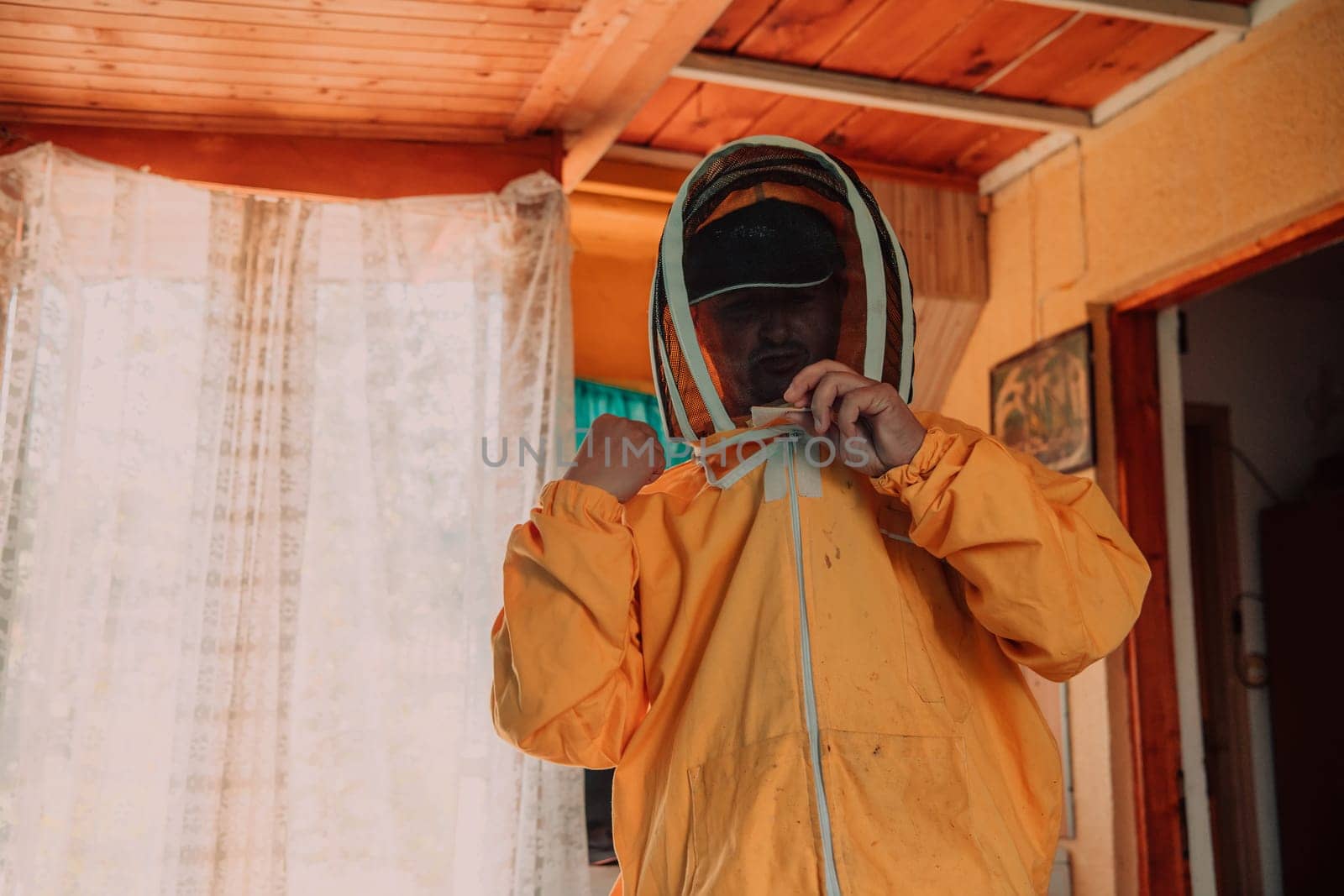 Beekeeper put on a protective beekeeping suit and preparing to enter the apiary.
