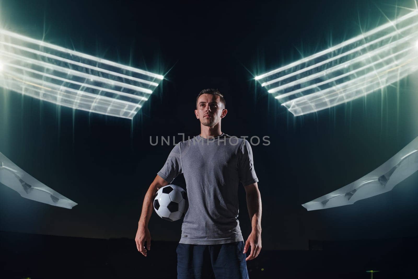 Portrait of a young handsome soccer player man on a street playing with a football ball