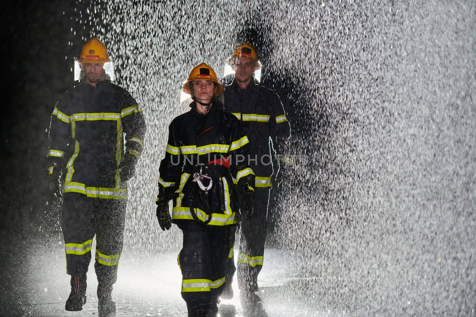 A group of professional firefighters marching through the rainy night on a rescue mission, their determined strides and fearless expressions reflecting their unwavering bravery and unwavering commitment to saving lives