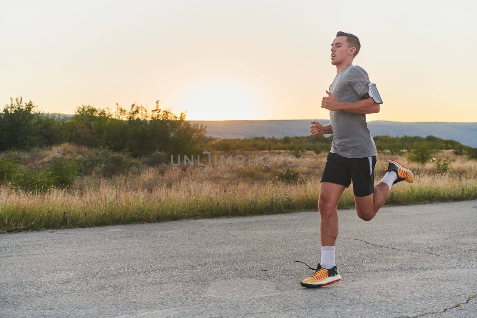 A young handsome man running in the early morning hours, driven by his commitment to health and fitness by dotshock
